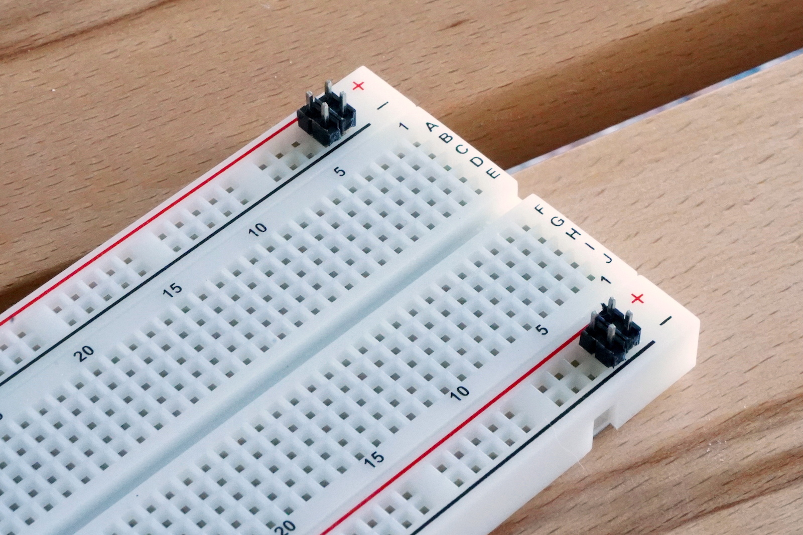 Placing the header pins into the breadboard.